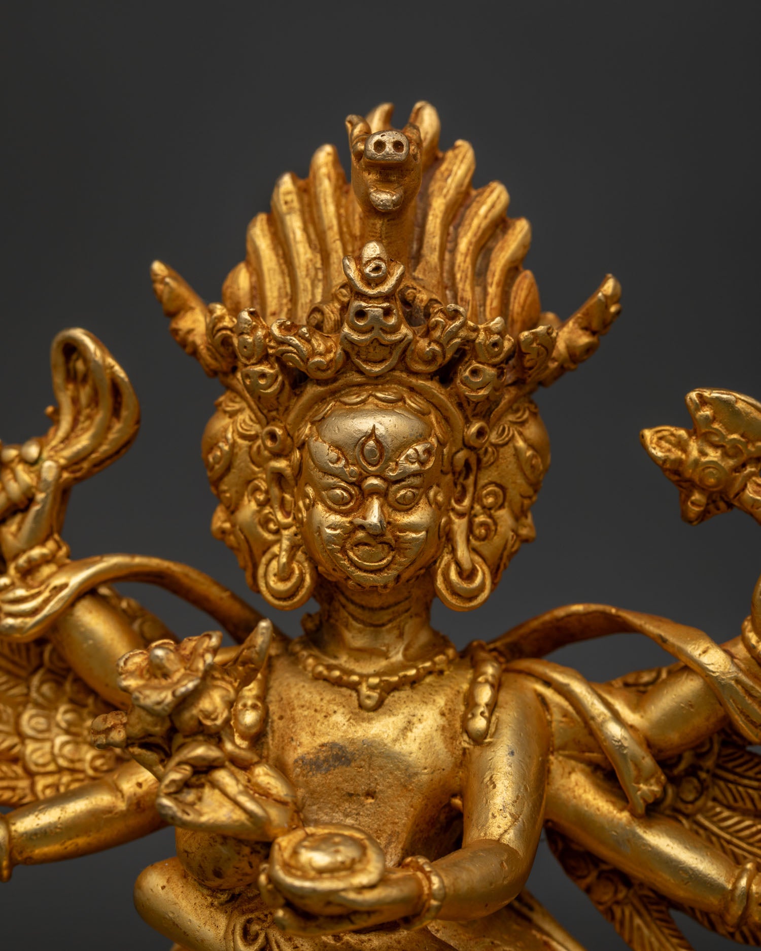 Close Up of Hayagriva Statue with Fierce Faces and Intricate Gold Details.