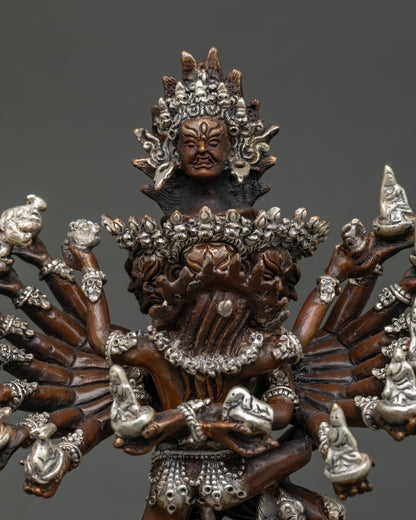 Close up of Hevajra statue multiple heads and sixteen arms holding sacred ritual objects.