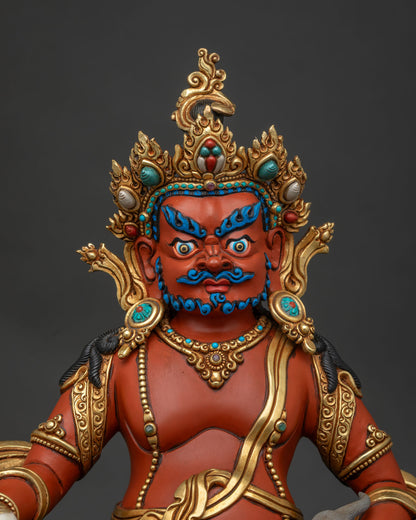 Close up of Jambhala Buddhist wealth deity holding a citron fruit and jewel mongoose with gold ornaments.