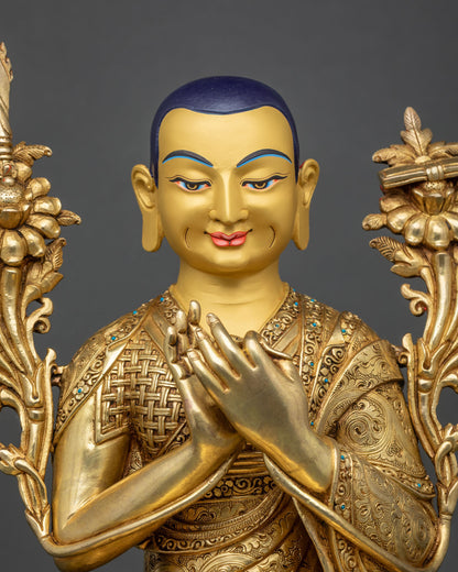 Close-up of Je Tsongkhapa face with dark blue scalp, serene smile and hands joined at chest