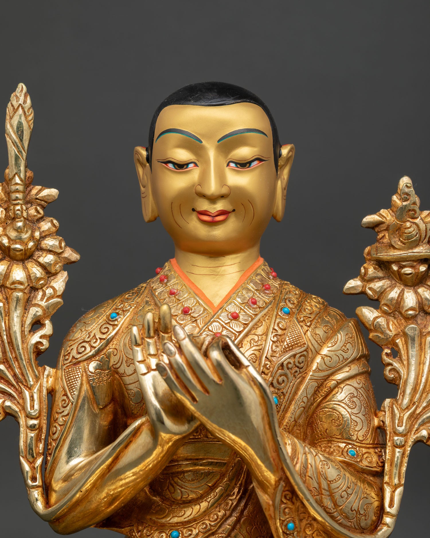 Close up of Je Tsongkhapa statue showing monastic robes Dharmachakra Mudra and intricate floral carvings