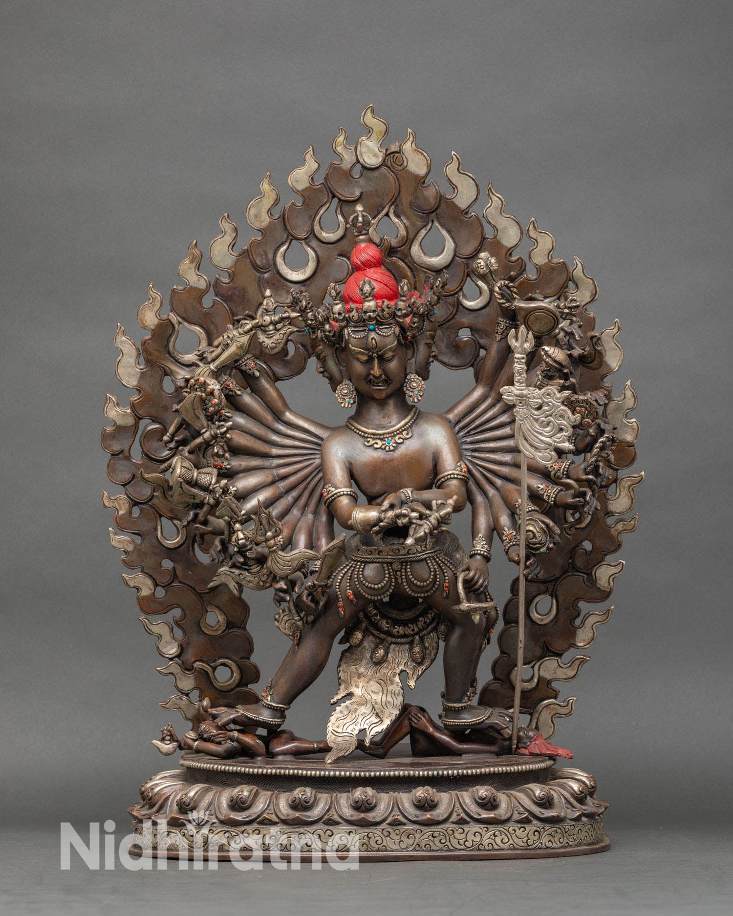 Close up of Kalachakra face and ritual implements in oxidized copper as a tantric deity