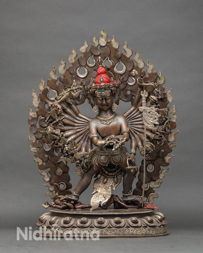 Close up of Kalachakra face and ritual implements in oxidized copper as a tantric deity