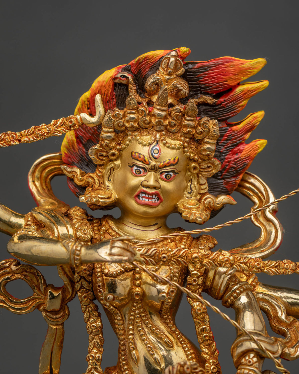 Close up of kurukulla statue with 24k gold painted face bow arrows hook and noose.