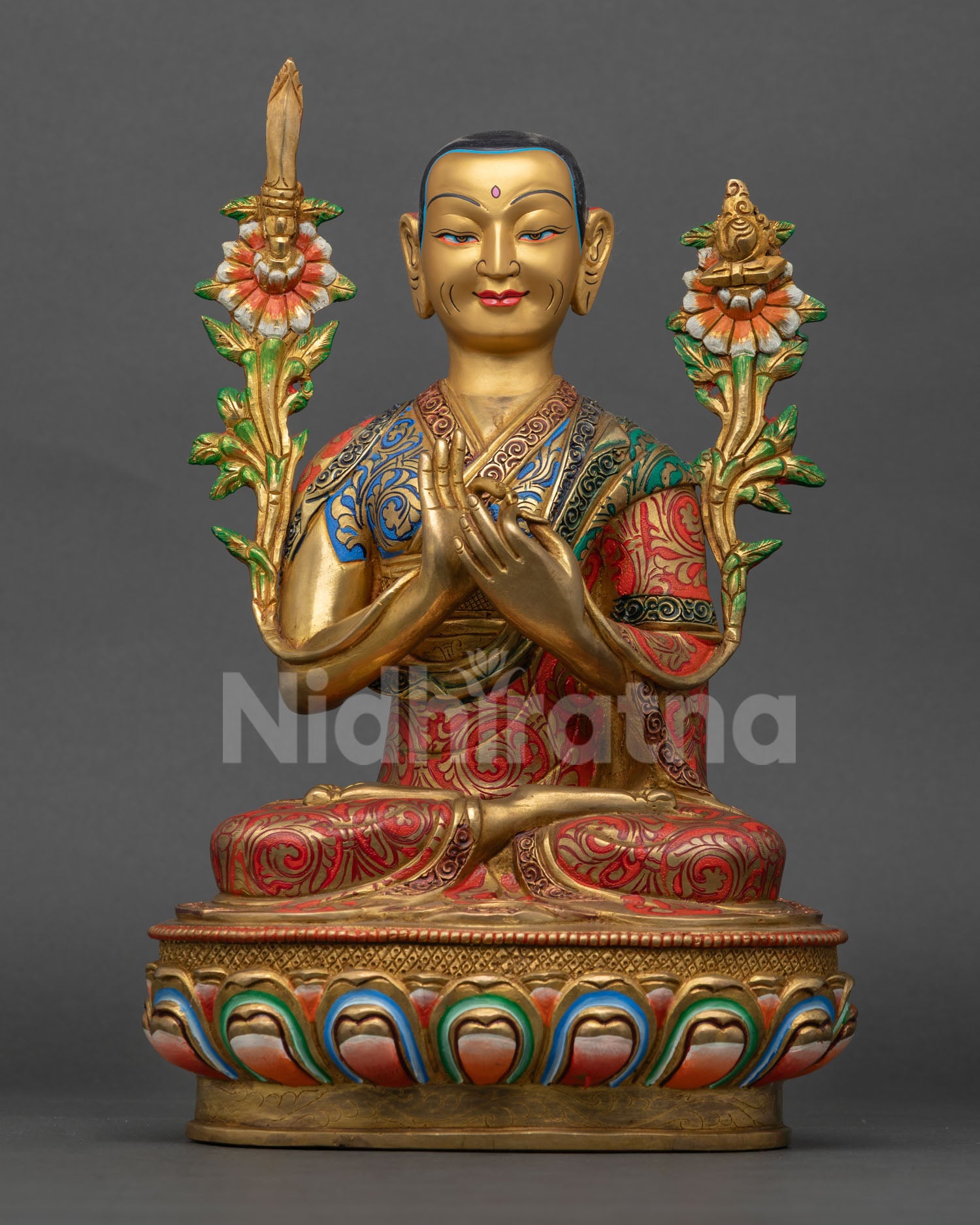 Close up of Lama Tsongkhapa statue with gold painted face and colorful traditional Tibetan Buddhist details