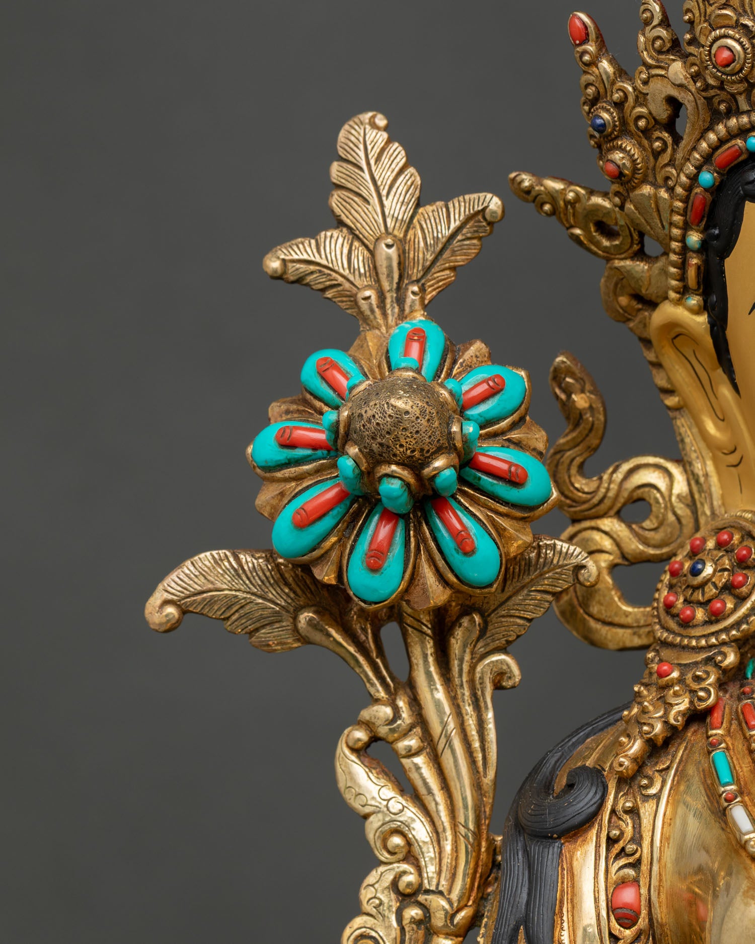Close-up of left utpala lotus with turquoise and coral inlay on White Tara statue