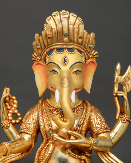 Close up of Lord Ganesha statue, showing gold painted face and intricate ornaments