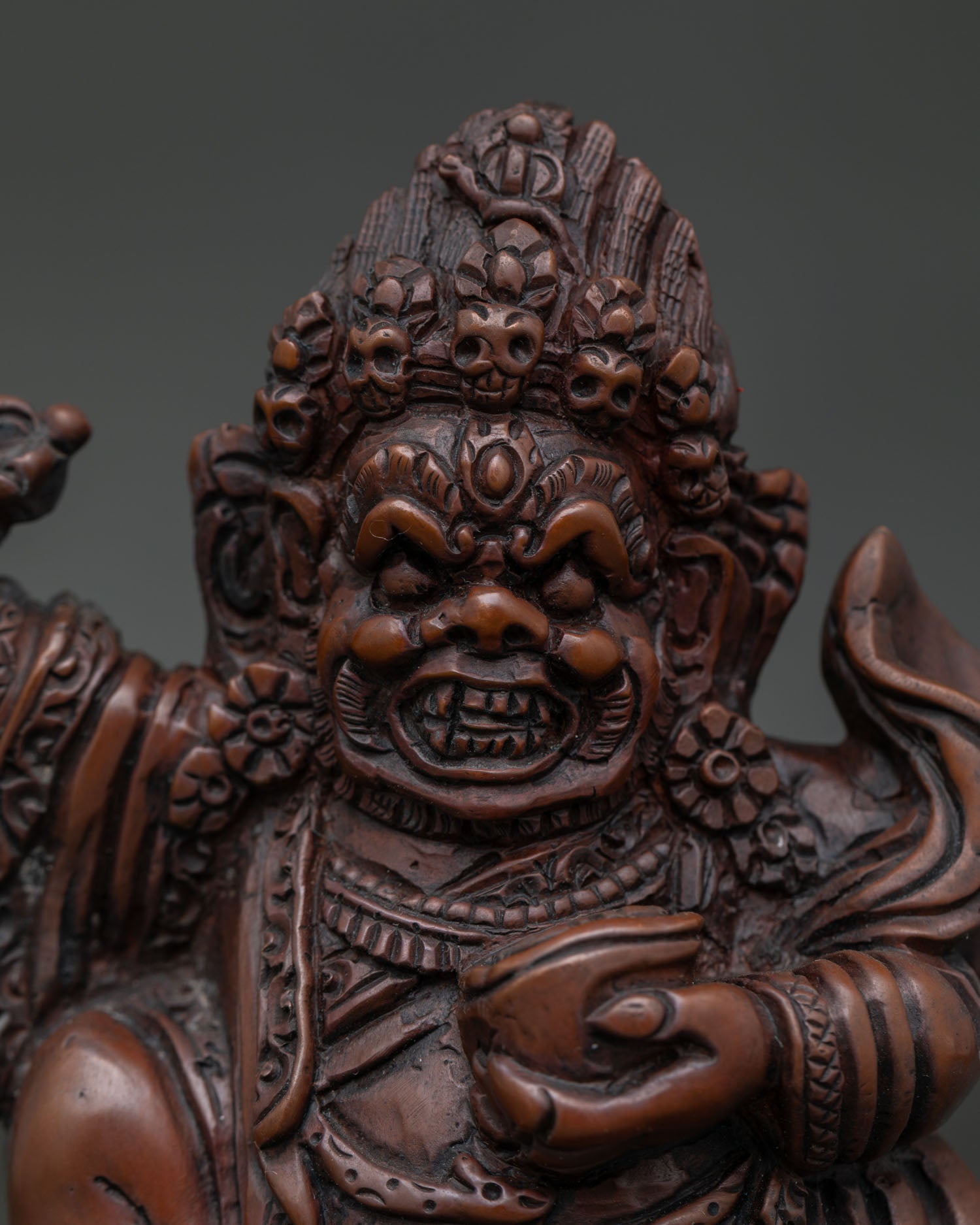 Close Up of Mahakala Bernagchen Statue with Wrathful Face and Sacred Flame Halo.