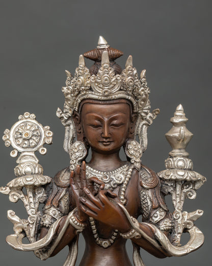 Close-up of Maitreya Buddha face, crown, and Dharma wheel on oxidized copper statue from Nepal