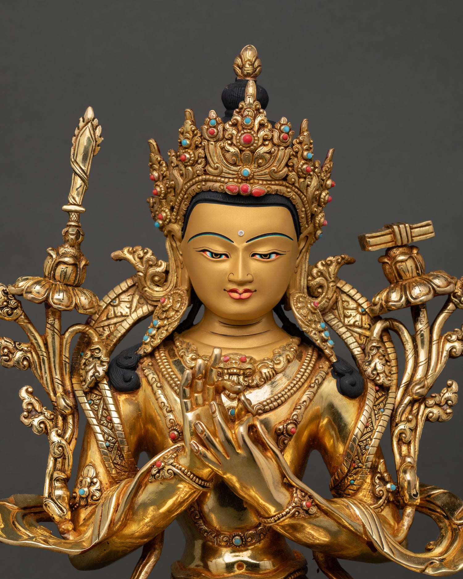 Close-up of Manjushri Bodhisattva face with five-jeweled crown, semi-precious stones, and detailed Himalayan Buddhist craftsmanship