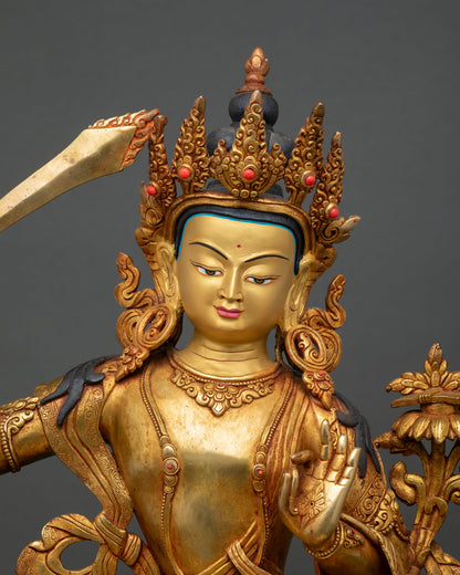 Close up of Manjushri Bodhisattva gold painted face with serene expression and intricate Himalayan artistry