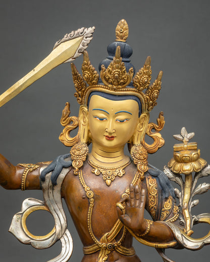 Close up of Manjushri copper statue with gold gilding and silver-plated scarves, Patan Nepal