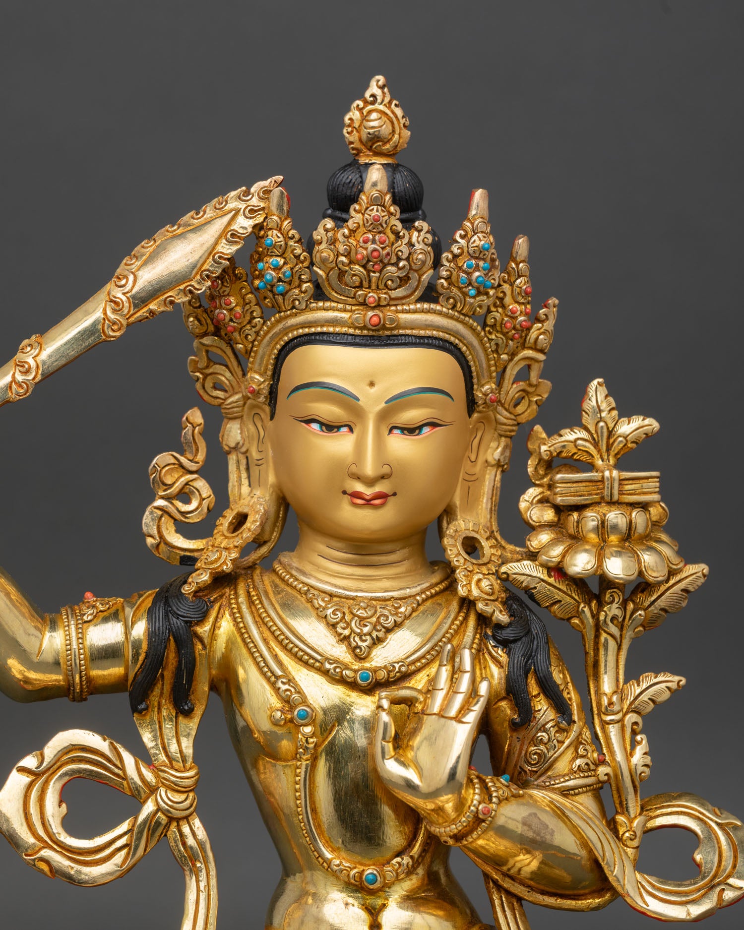 Close up of Manjushri gold-painted face flaming sword Prajnaparamita Sutra intricate Newari artistry