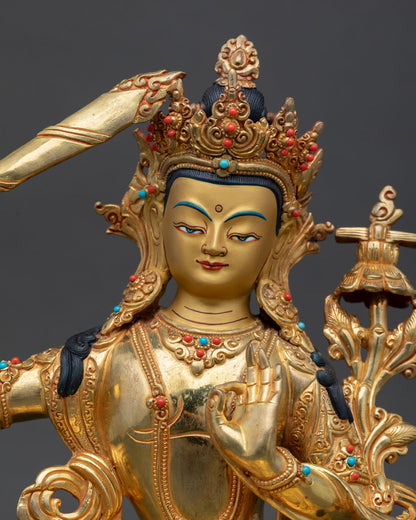 Close-up of Manjushri's gold-painted face holding a flaming wisdom sword