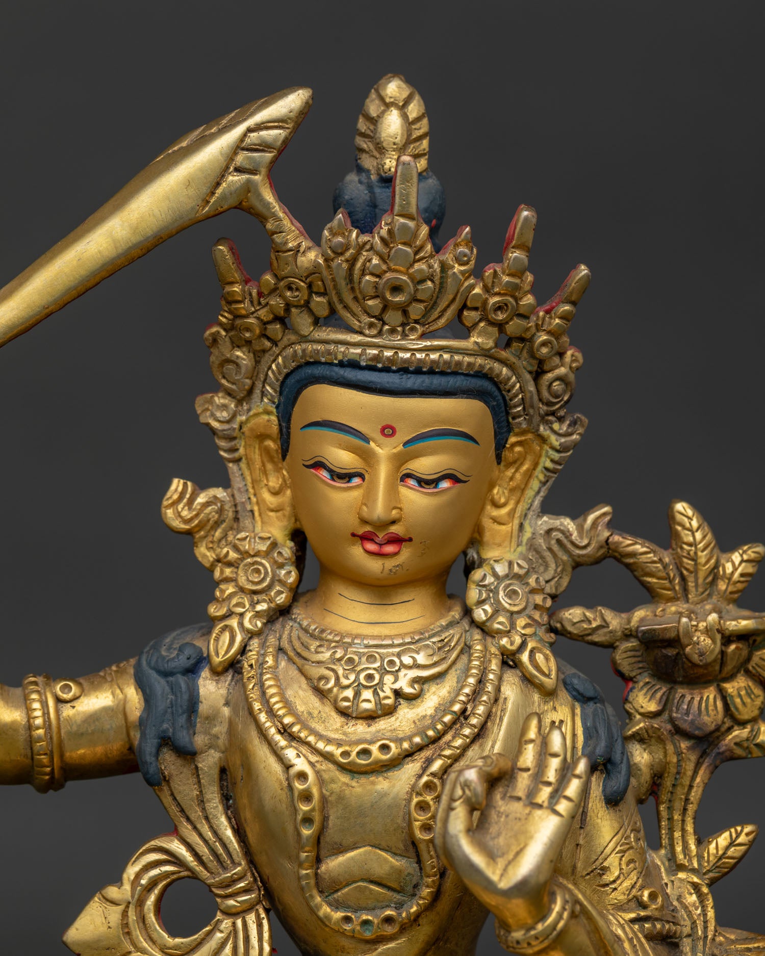 Close Up of Manjushri Gold Painted Face with Flaming Wisdom Sword and Utpala Flower