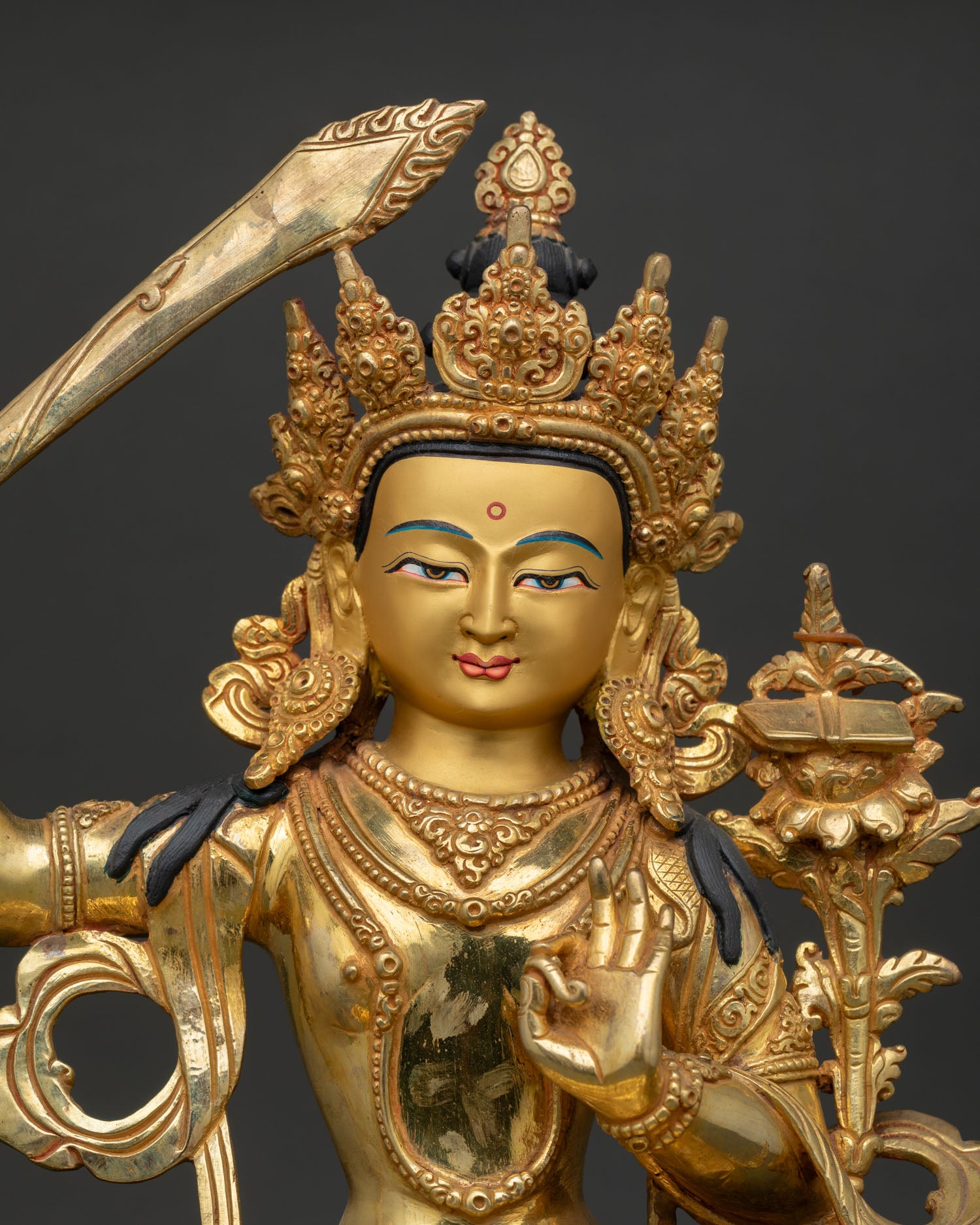 Close Up of Manjushri Statue Holding Utpala Flower with Prajnaparamita Sutra.