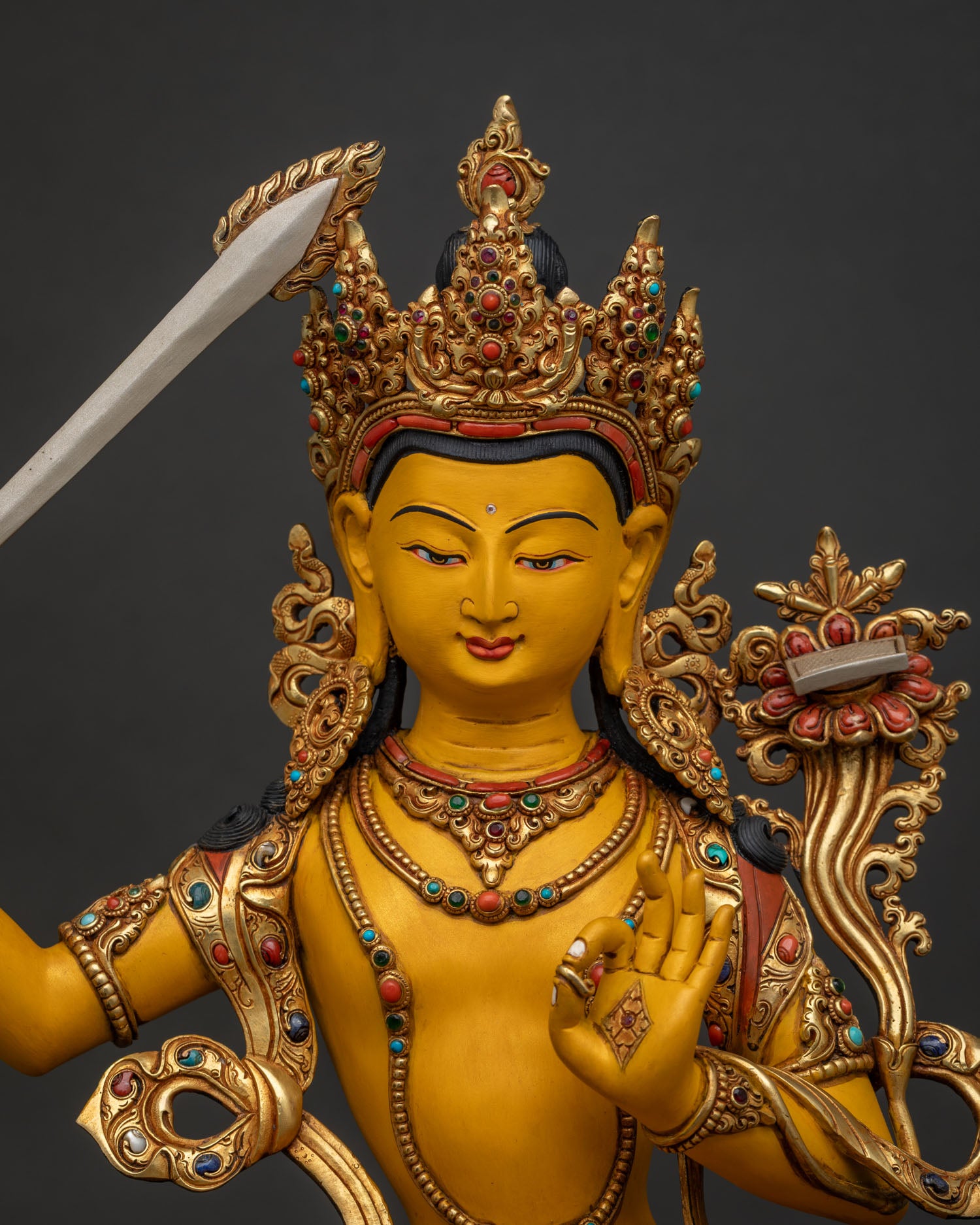 Close-up of Manjushri statue showing gold-gilded crown and turquoise stone accents