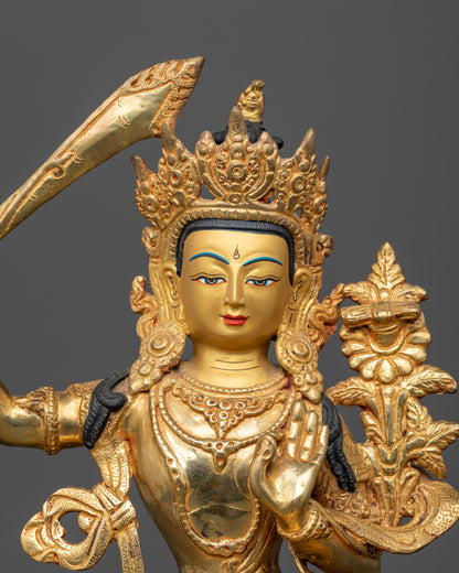 Close up of Manjushri Statue with 24K gold face and carved floral robe.