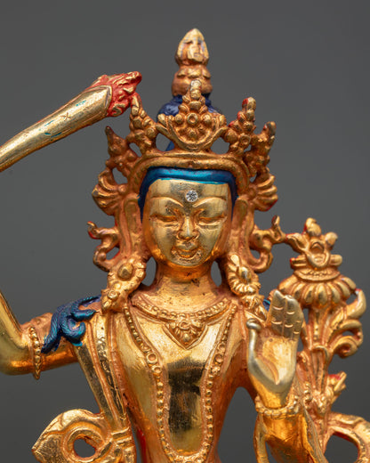 close up of manjushri statue with gold gilded crown and sacred sword