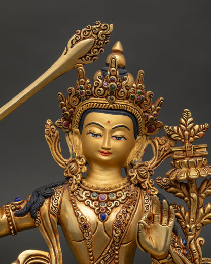Close-up of Manjushri statue with intricate details, gold gilding, and gemstone accents