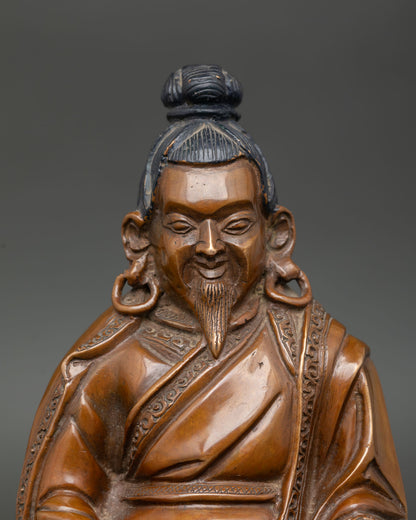 Close up of Marpa Buddhist statue, showing detailed monk robes and peaceful expression