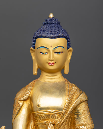 Close up of medicine buddha 24k gold painted face with serene calm expression.