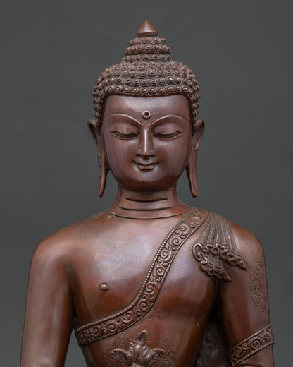 Close up of Medicine Buddha copper statue with serene face and oxidized finish detailing