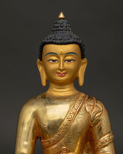 Close up of Medicine Buddha gold painted face with intricate floral motif robe.