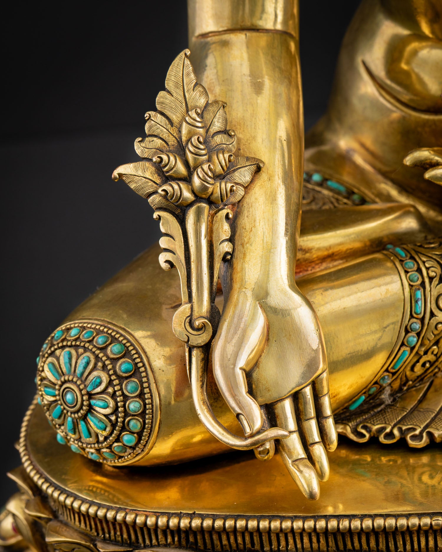 Close-up of Medicine Buddha right hand holding myrobalan plant with turquoise lotus detail, Nepal statue