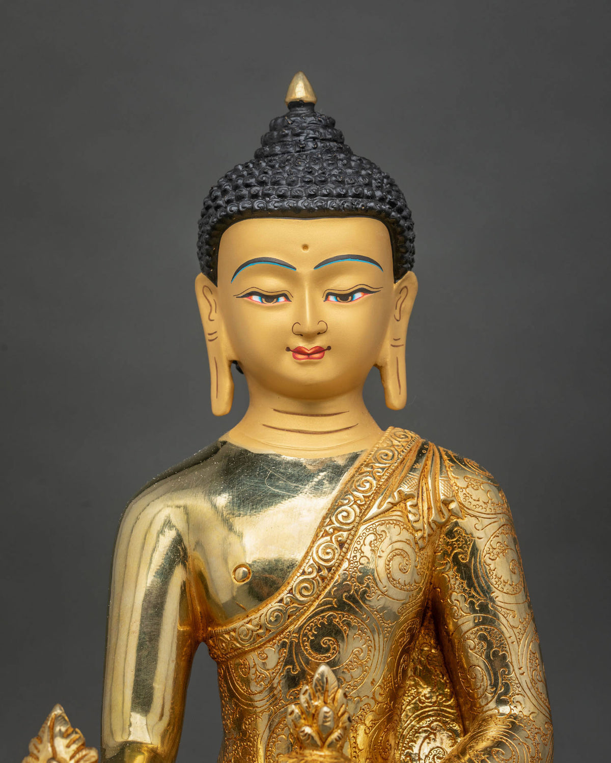Close-up of Medicine Buddha Statue featuring a serene gold-painted face, finely detailed Buddhist features