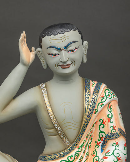 close up of milarepa statue seated at ease with skull cup and gold trimmed floral robe