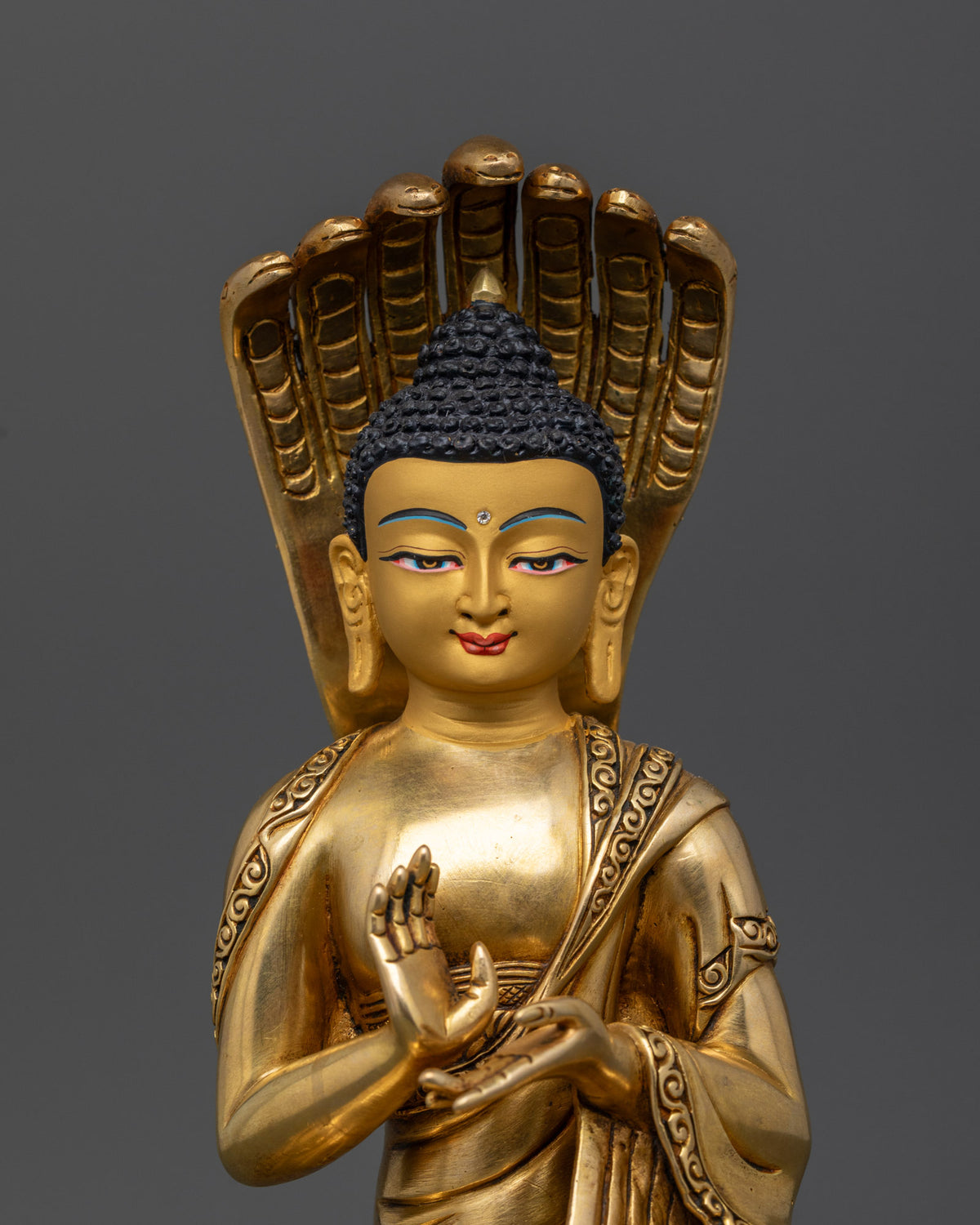 Close up of Nagarjuna statue featuring a 24K gold painted face and finely carved details.