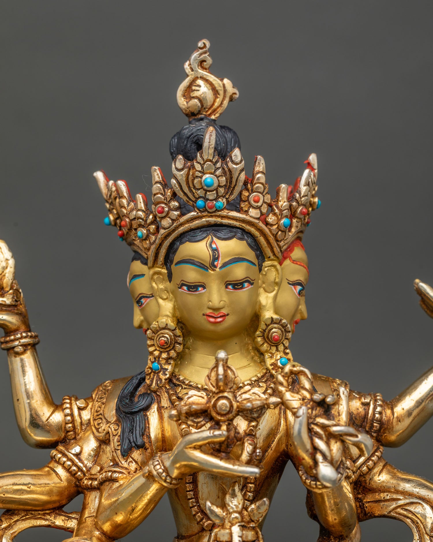 Close up of Namgyalma statue gold painted face with semi precious stones and fine details.