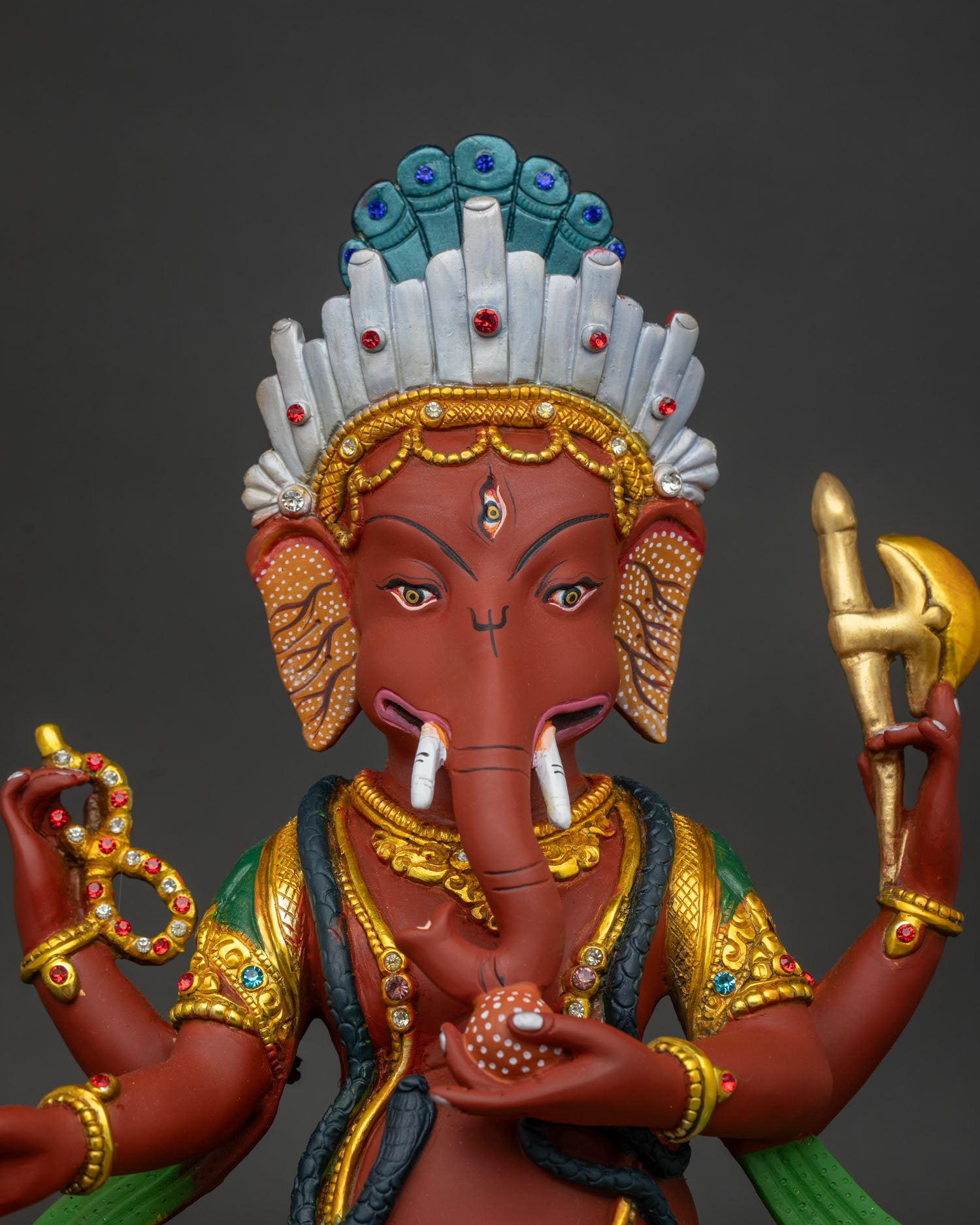 Close up of Nepalese Ganesh idol with copper craftsmanship and vibrant acrylic artwork