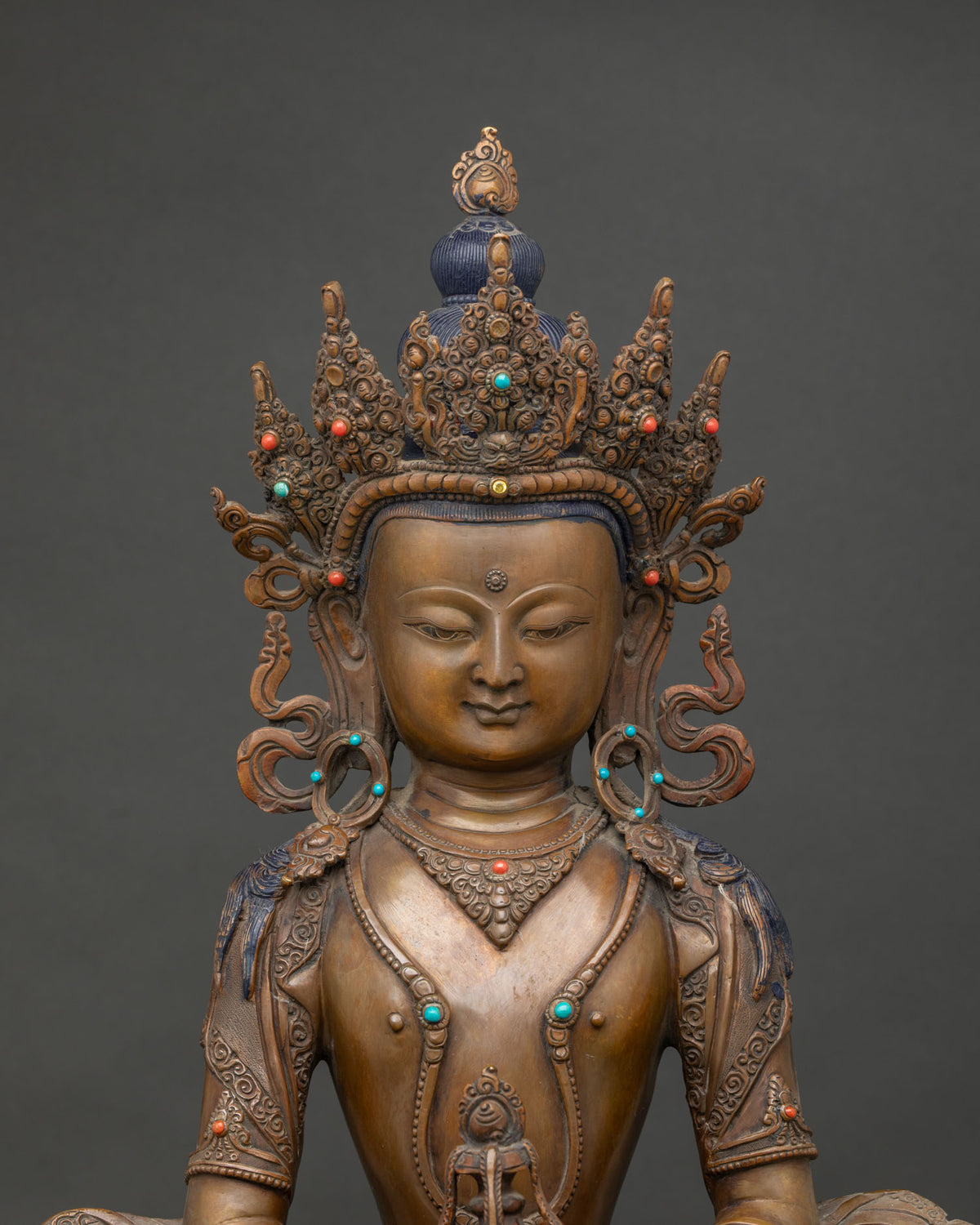 Close-up of oxidized copper Amitayus statue showing crown, jewelry and kalasha detail