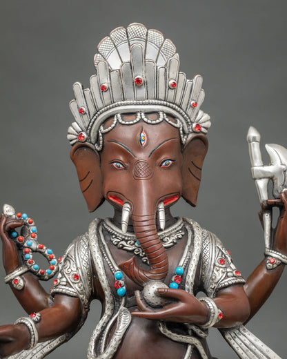 Close up of oxidized copper Ganesh idol with silver accents, ruby and turquoise stones, Newari art