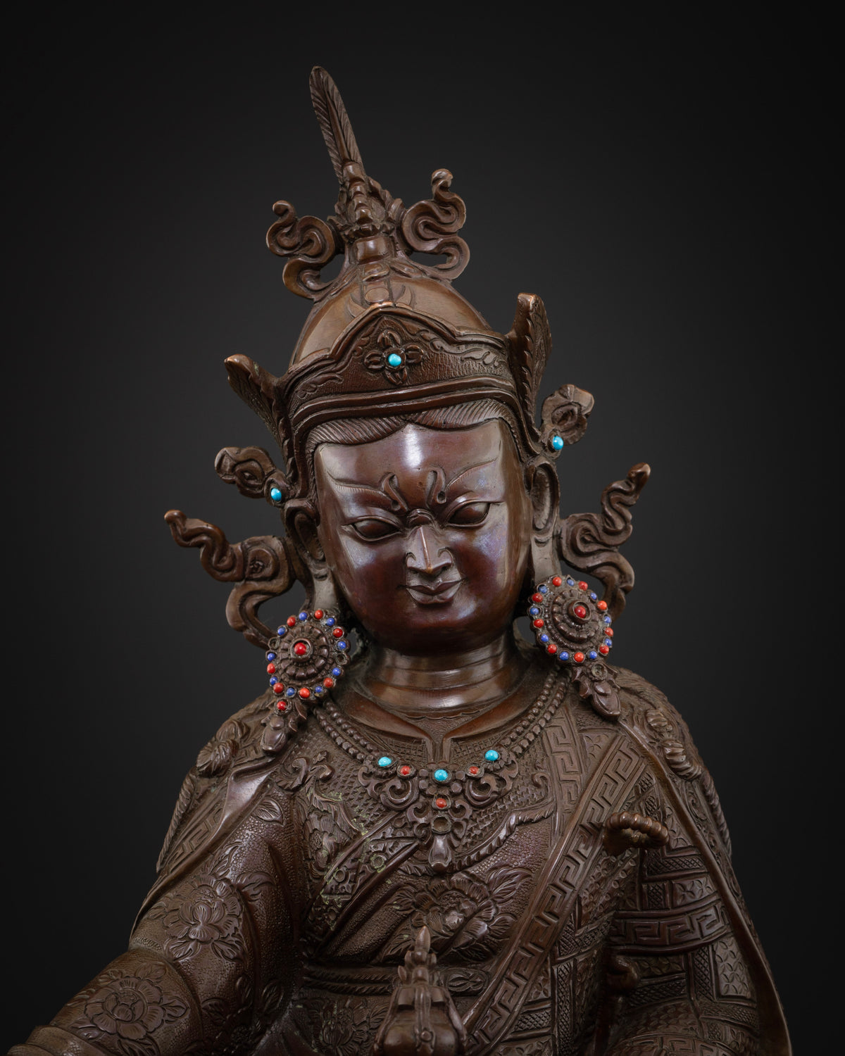 Close-up of oxidized copper Guru Rinpoche statue showing lotus hat, ornaments and upper robe