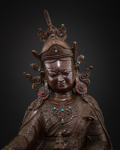 Close-up of oxidized copper Guru Rinpoche statue showing lotus hat, ornaments and upper robe