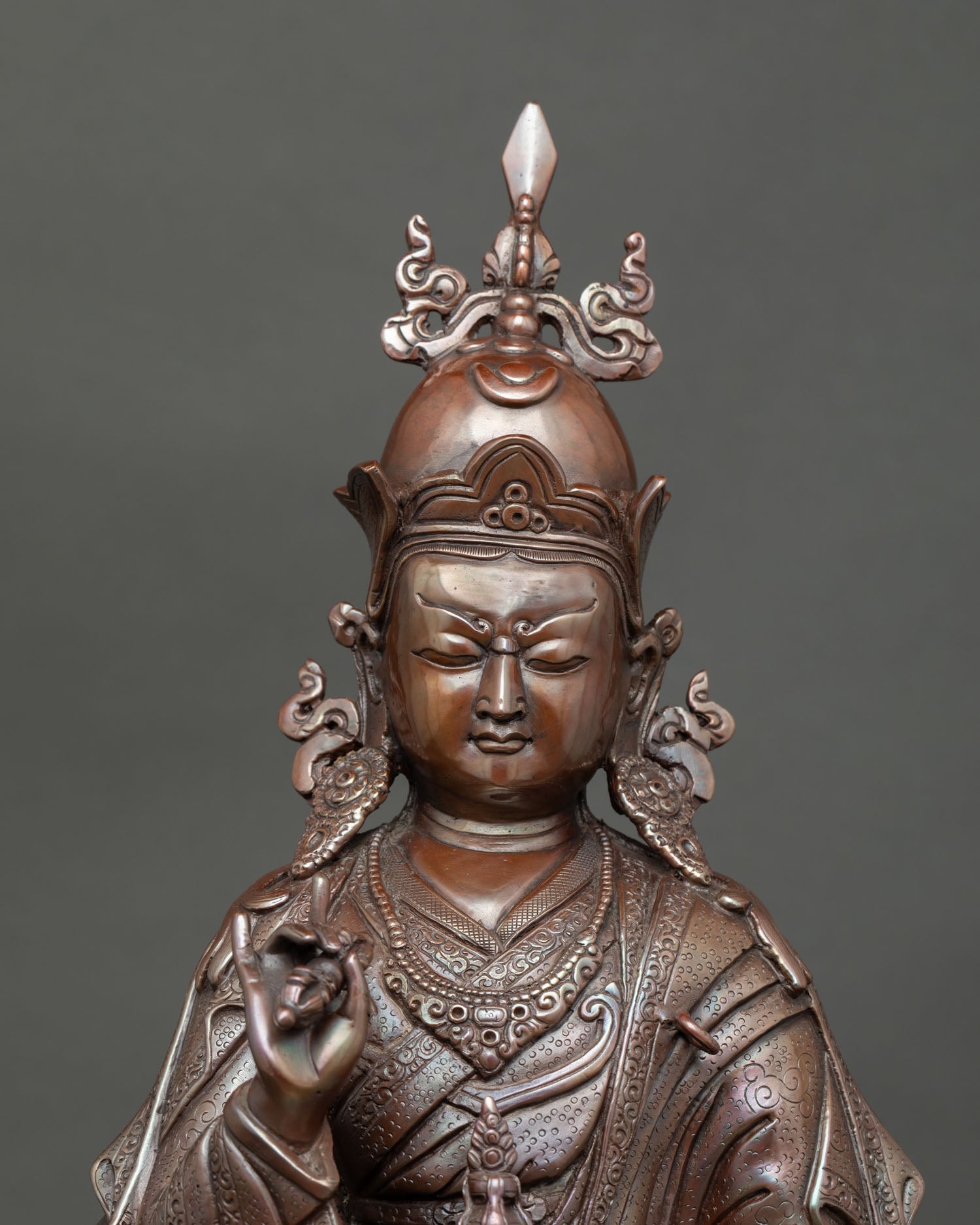 Close up of oxidized copper Tsokye Dorje statue holding a vajra and skull cup