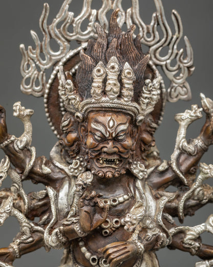 Close-up of oxidized copper Ucchusma statue showing wrathful face, multiple arms and silver detailing