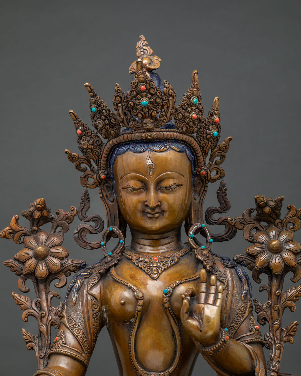 Close-up of oxidized copper White Tara statue showing crown, jewelry and lotus detail