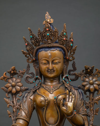 Close-up of oxidized copper White Tara statue showing crown, jewelry and lotus detail
