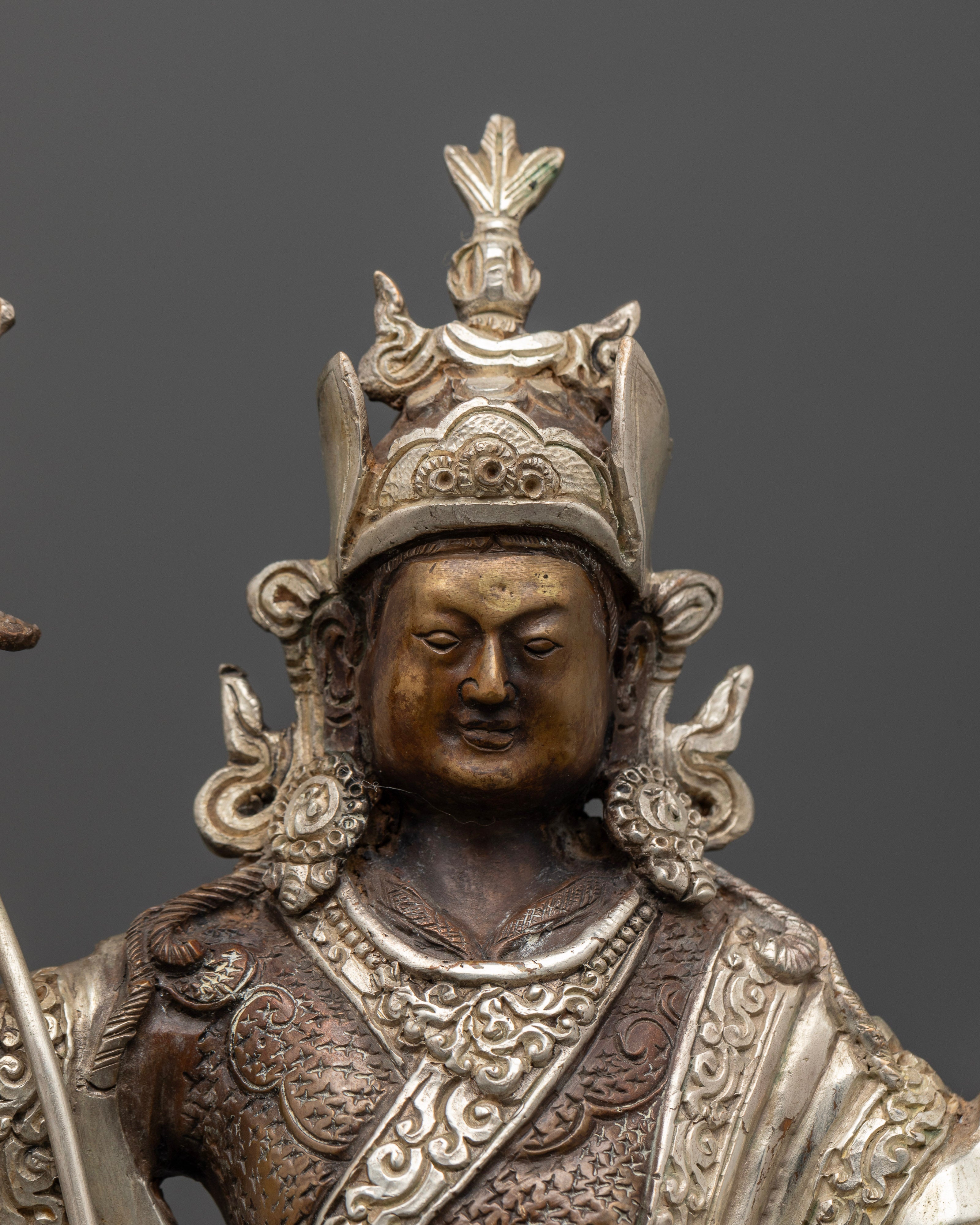 Close up of Padmasambhava Statue with detailed face and traditional Himalayan craftsmanship