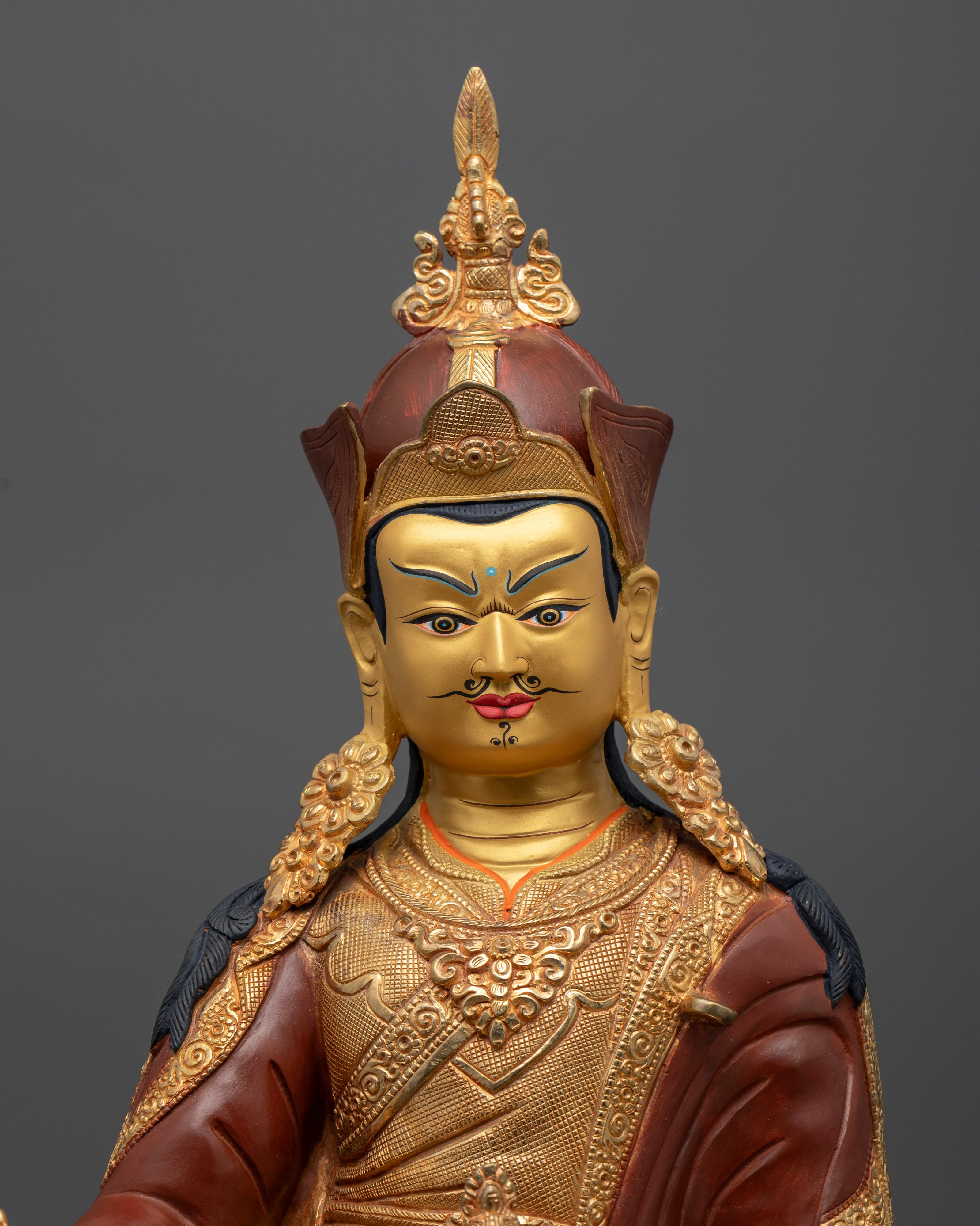 Close up of Padmasambhava Statue with gold painted face and Himalayan craftsmanship details