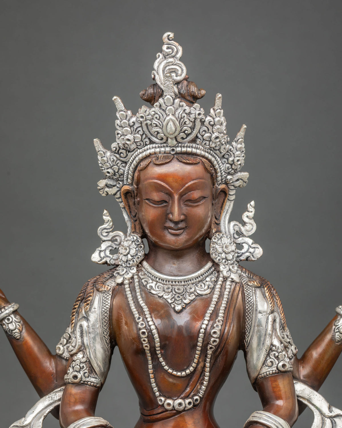 Close up of Prajnaparamita statue’s silver-plated crown, necklaces and oxidized copper torso