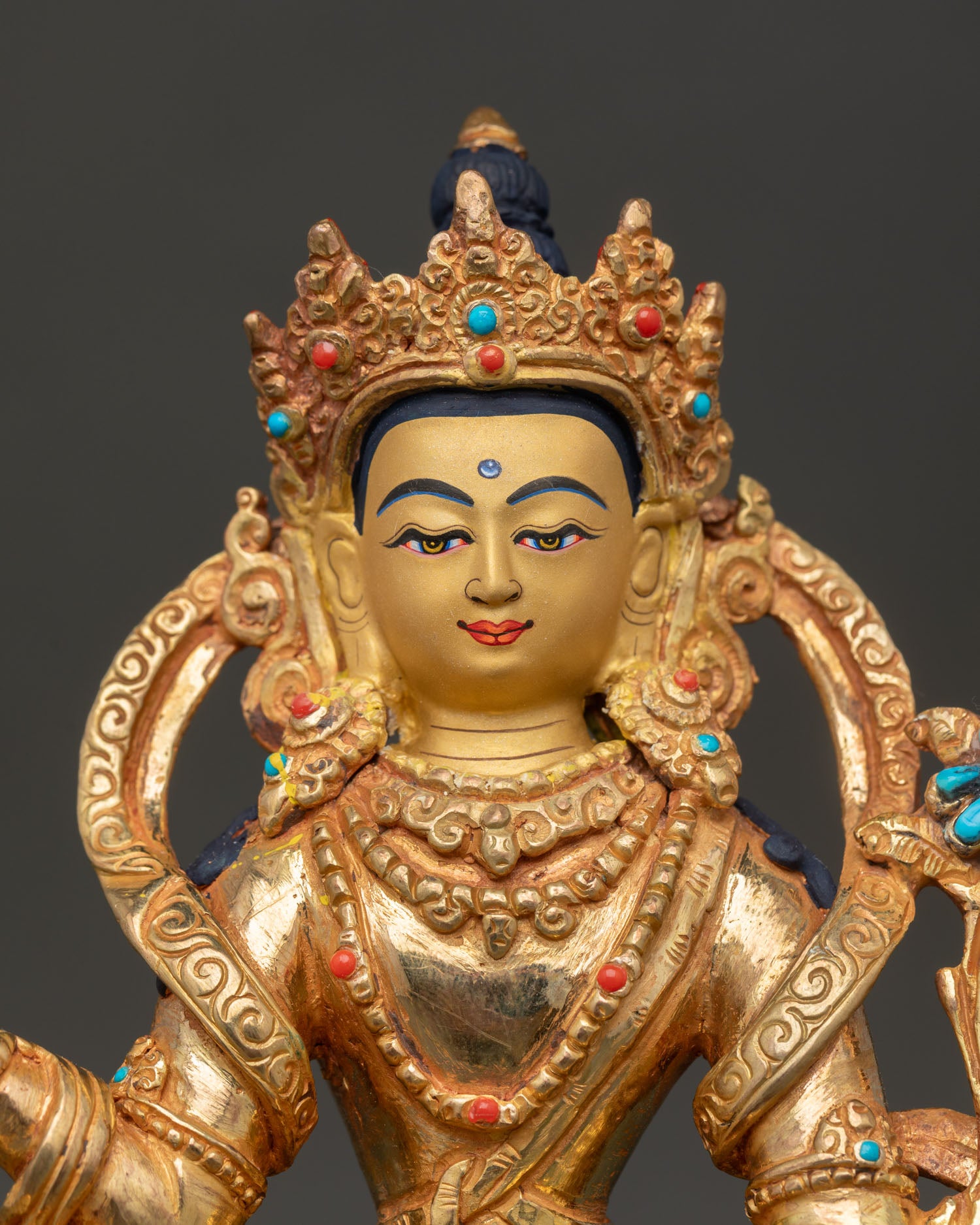 Close-up of Samantabhadra Buddha statue with gold gilding and gemstone inlay details