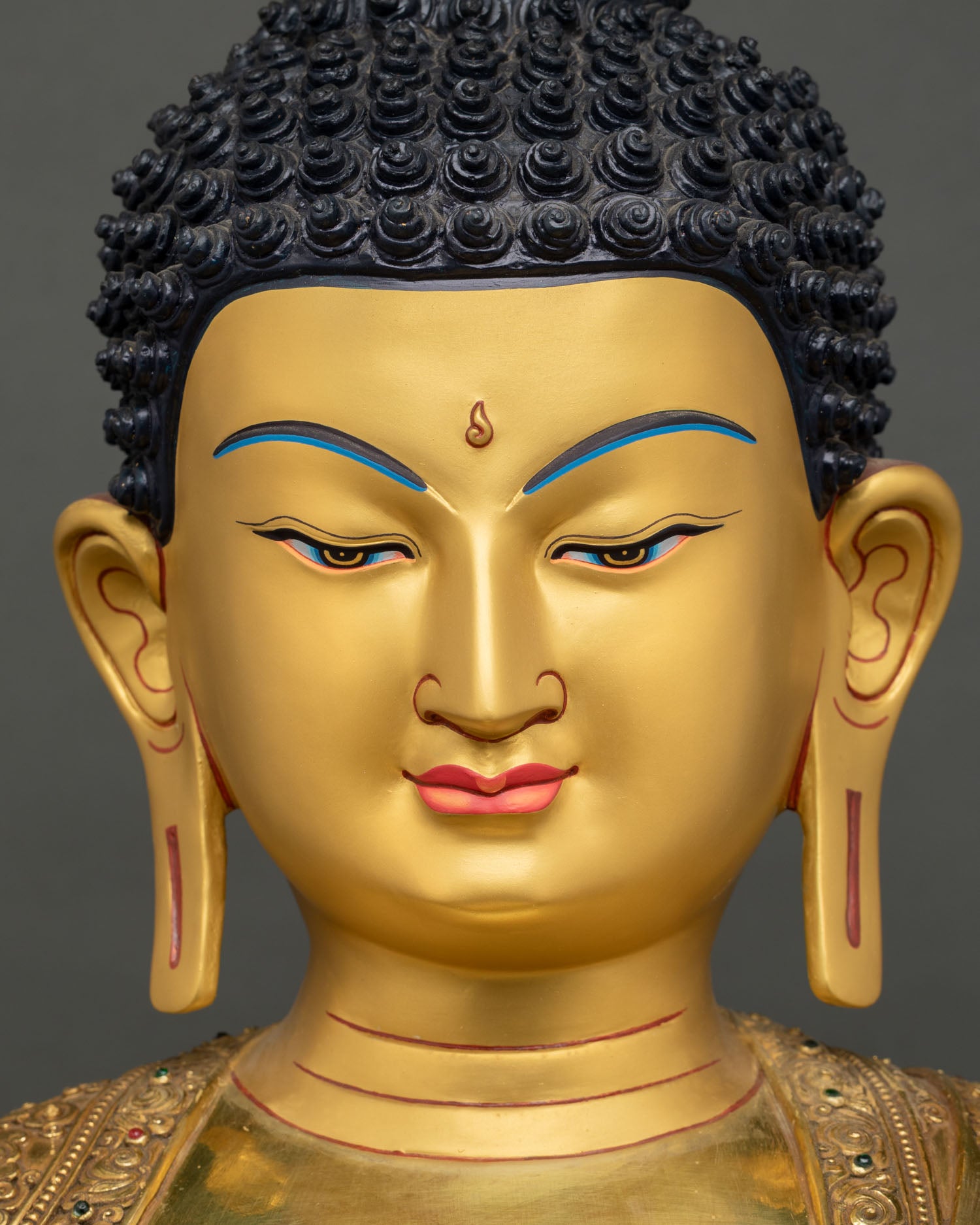 Close-up of Shakyamuni Buddha face showing serene expression and urna mark