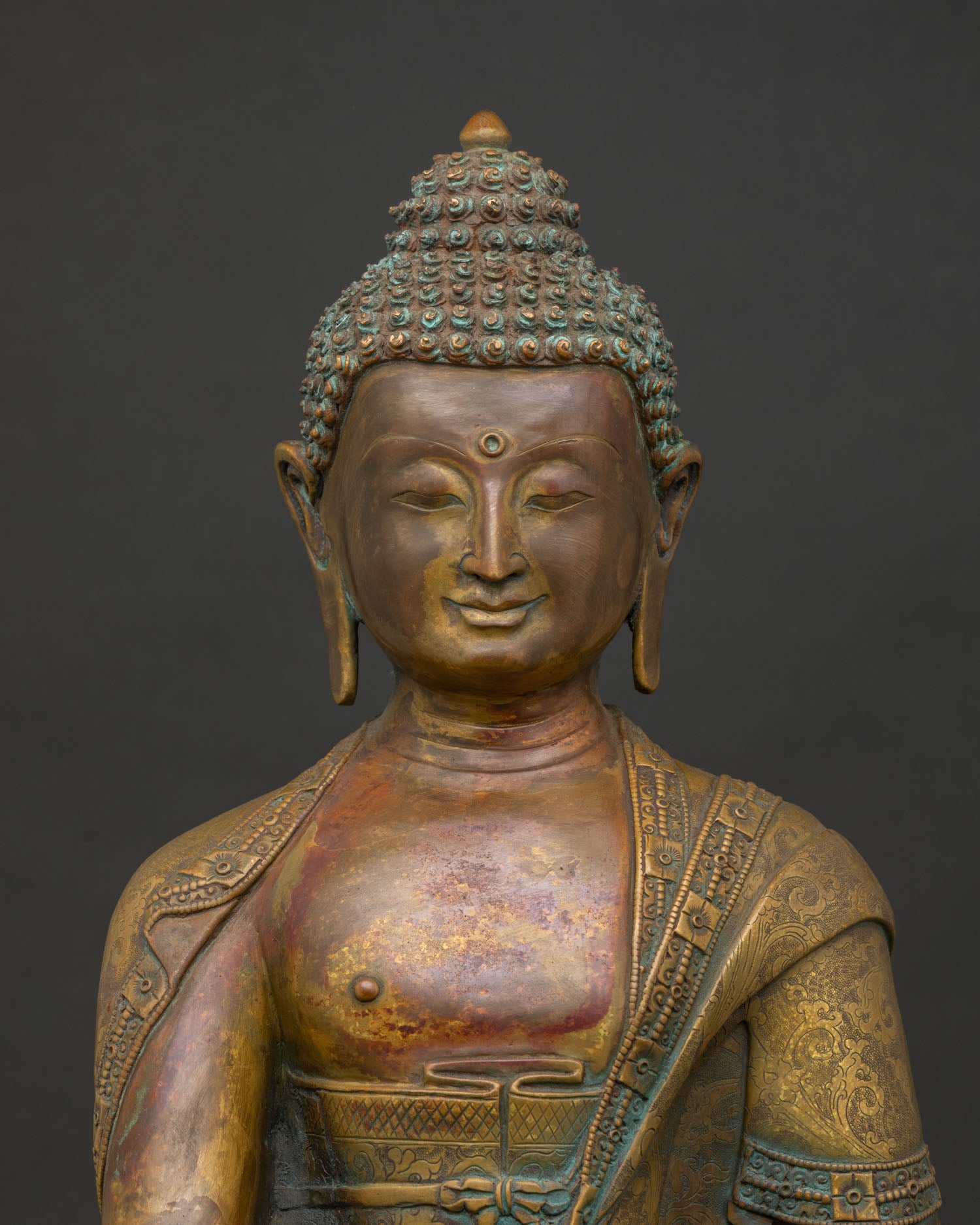Close up of Shakyamuni Buddha face with handcarved monk robe and antique oxidized copper finish.