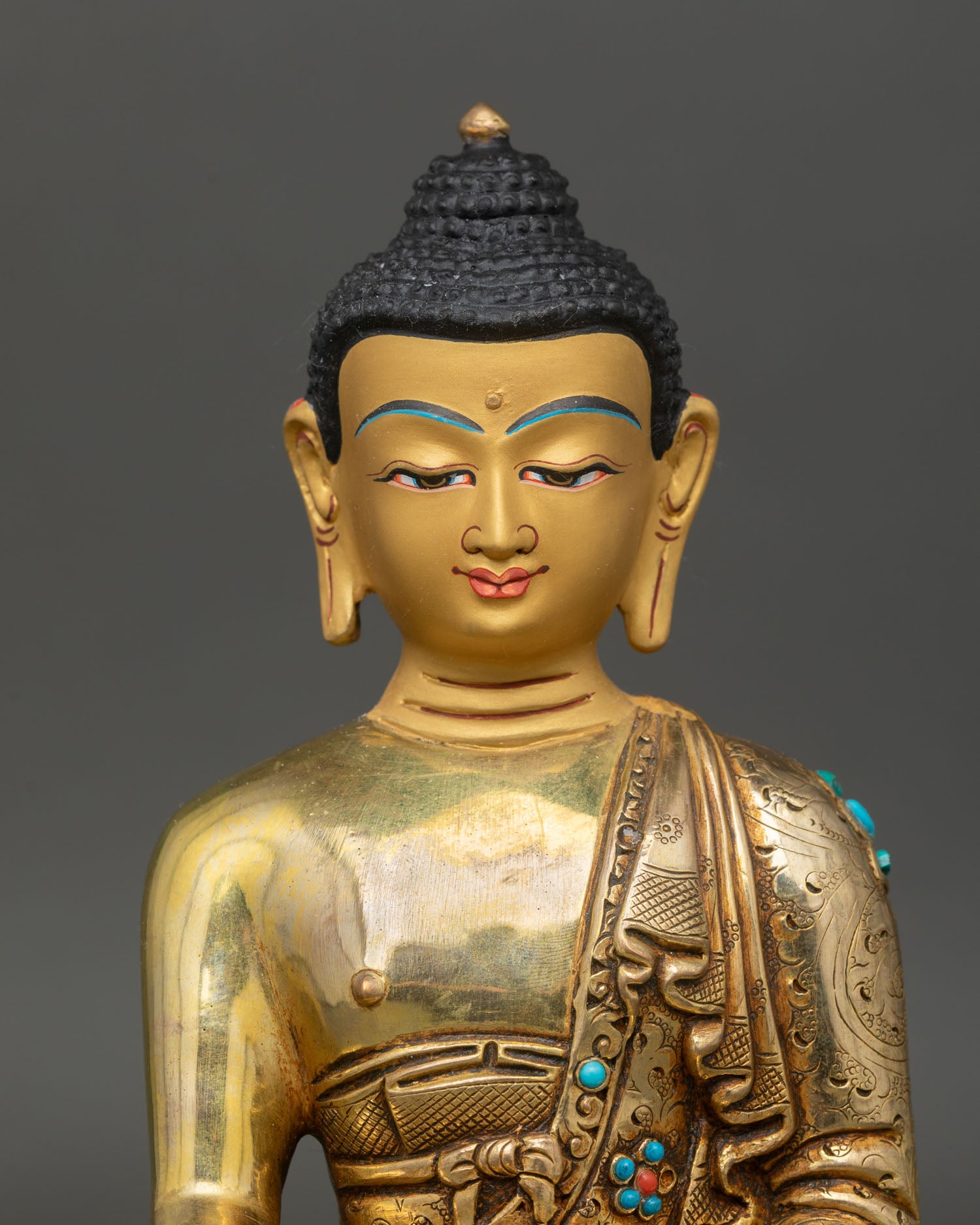 Close up of Shakyamuni Buddha gold painted face intricate Newari art handcrafted copper statue