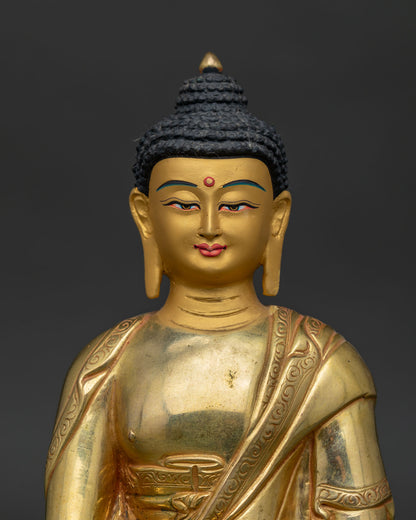 Close up of Shakyamuni Buddha gold painted face with handcarved monk's robe.